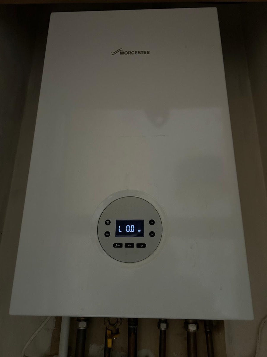 A wall-mounted gas combi boiler showing a low-pressure reading during a property check